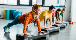 grupo de niños y niñas haciendo ejercicio con step