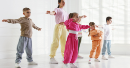 monitora con niños y niñas haciendo zumba